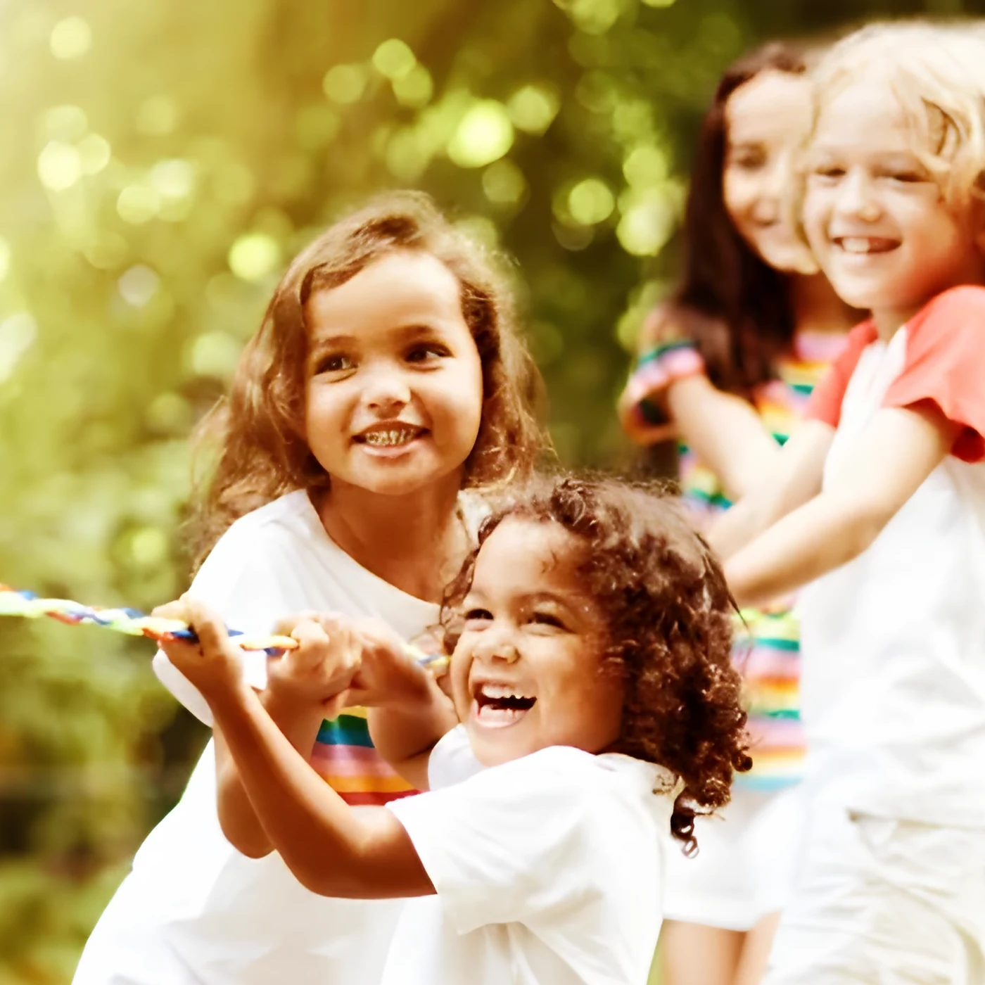 Lachende Kinder ziehen gemeinsam an einem Seil